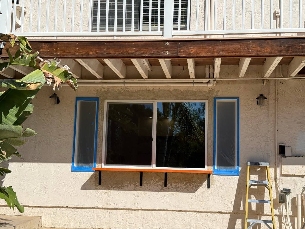 Windows taped and stucco patched on the casita before finish paint