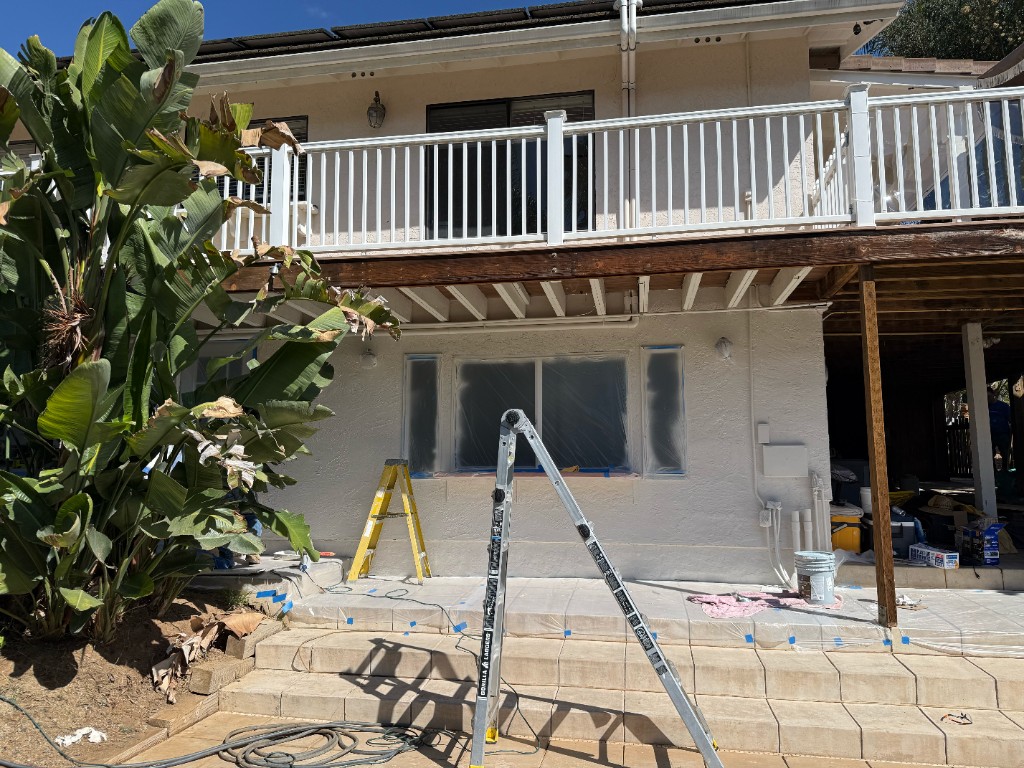 Lower casita masked and in the middle of exterior paint