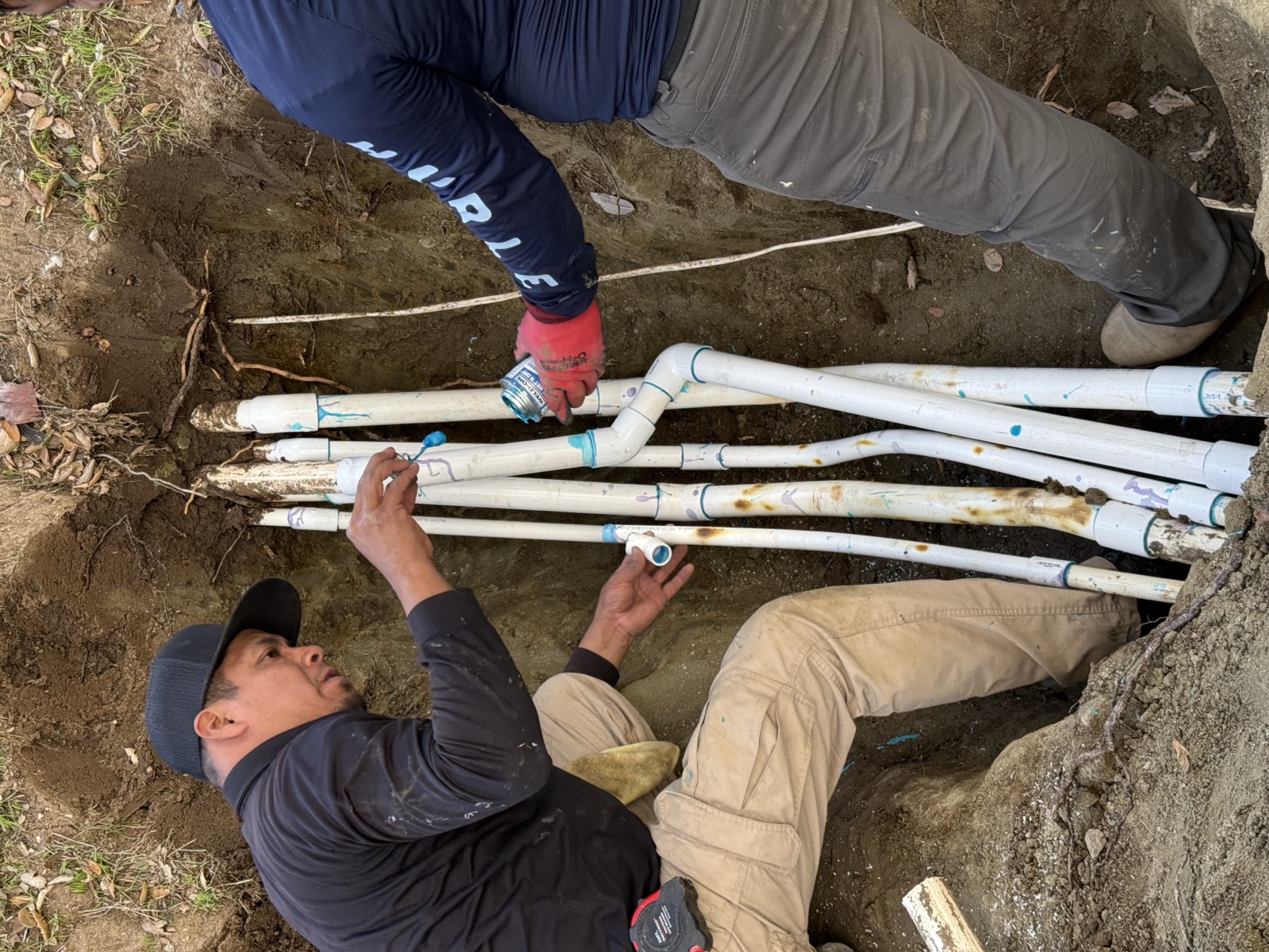 CRG crew repairing PVC irrigation laterals in an excavated hole