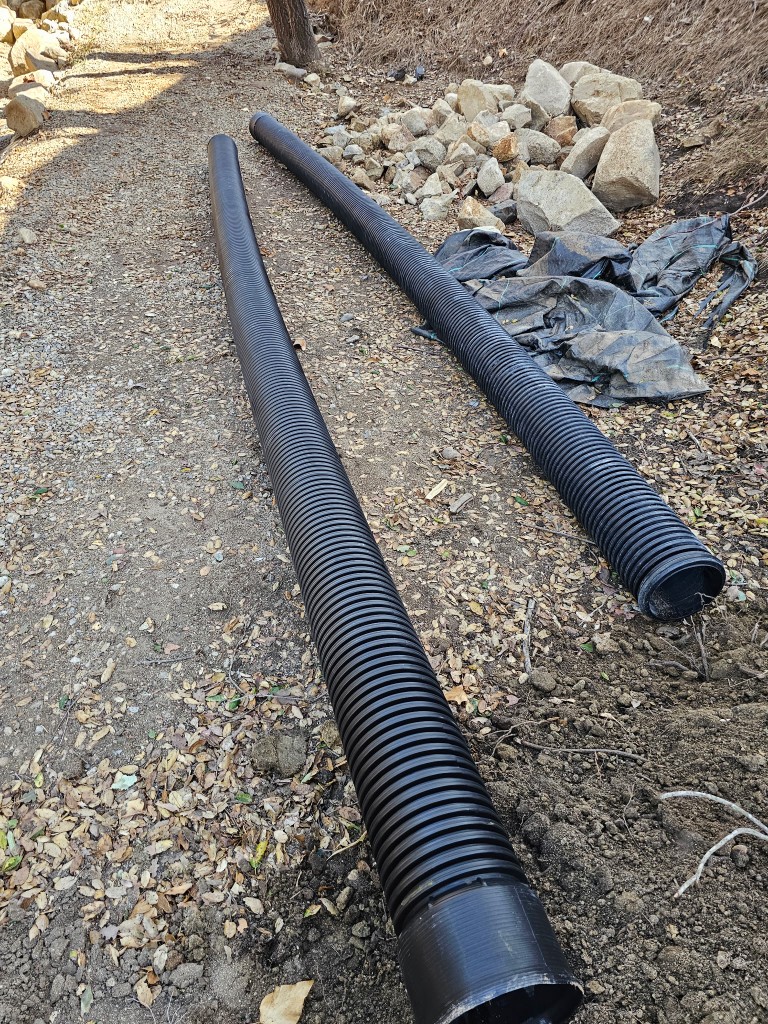 Corrugated runoff pipe staged on the ground